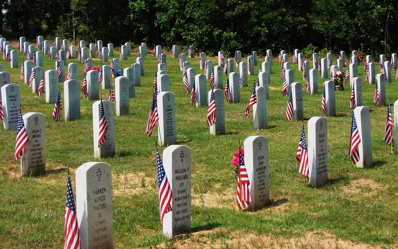 Graveyard with military grave stones with American flags.